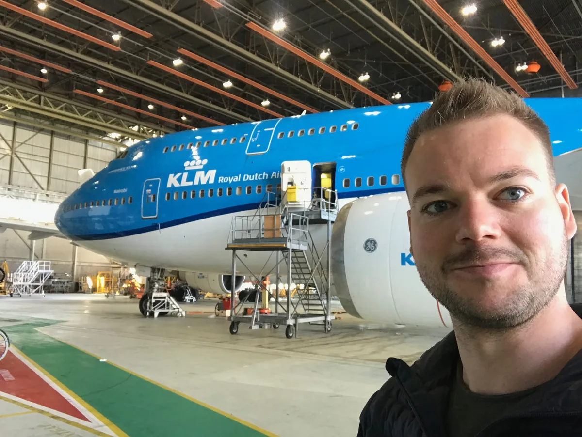 Max Redecker in the base maintenance hangar, with a KLM aircraft on work stands behind him.